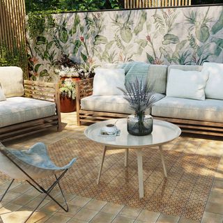 living room with plant print tile wall and sofa