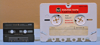 A compact casette next to a quarter-inch tape cartridge.