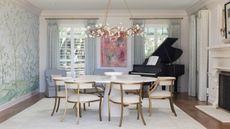 dining room with round table, piano and mural