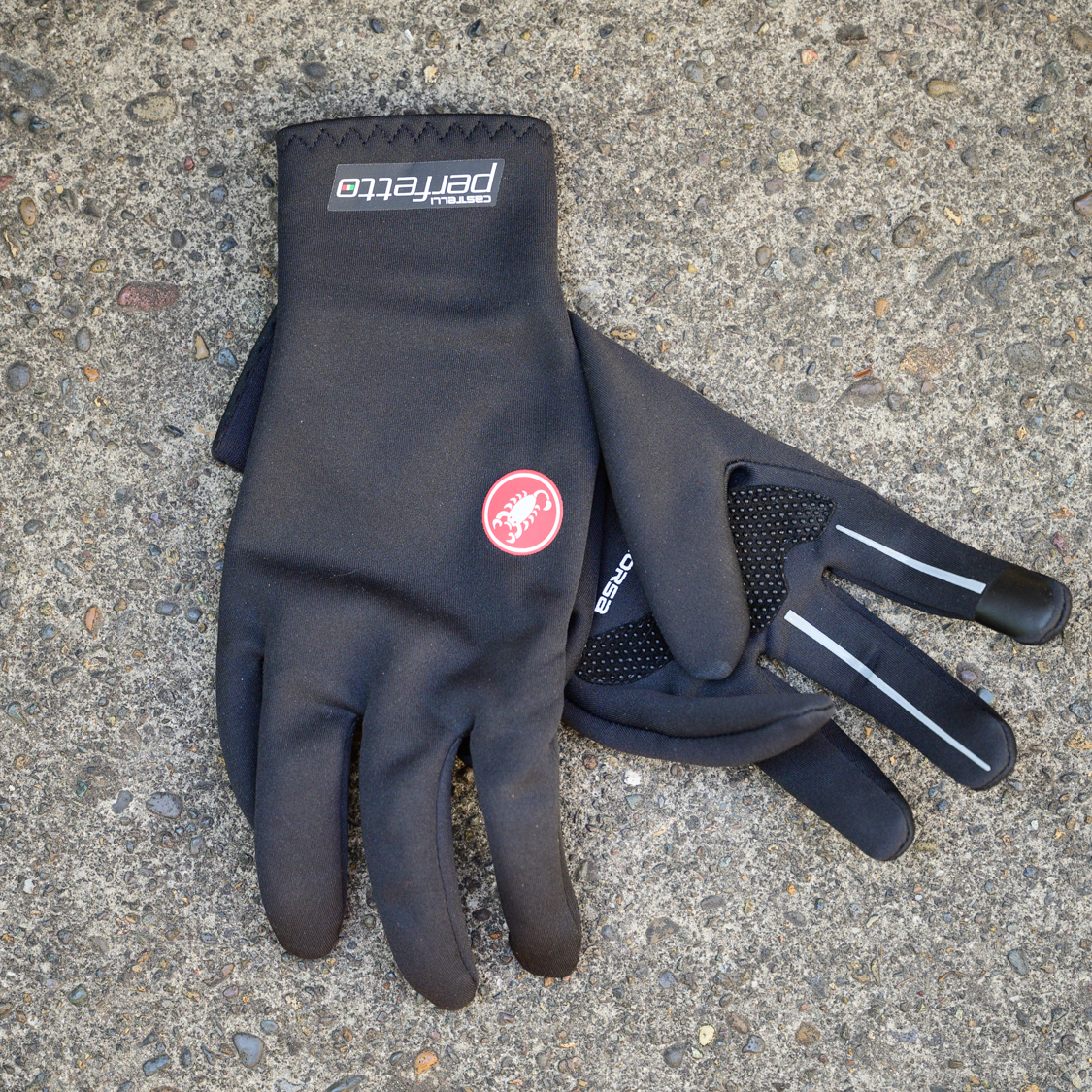 A pair of black Castelli Perfetto Ros cycling gloves on a concrete floor