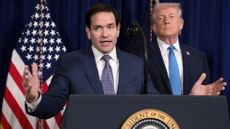 Marco Rubio speaks with Donald Trump looming behind him.