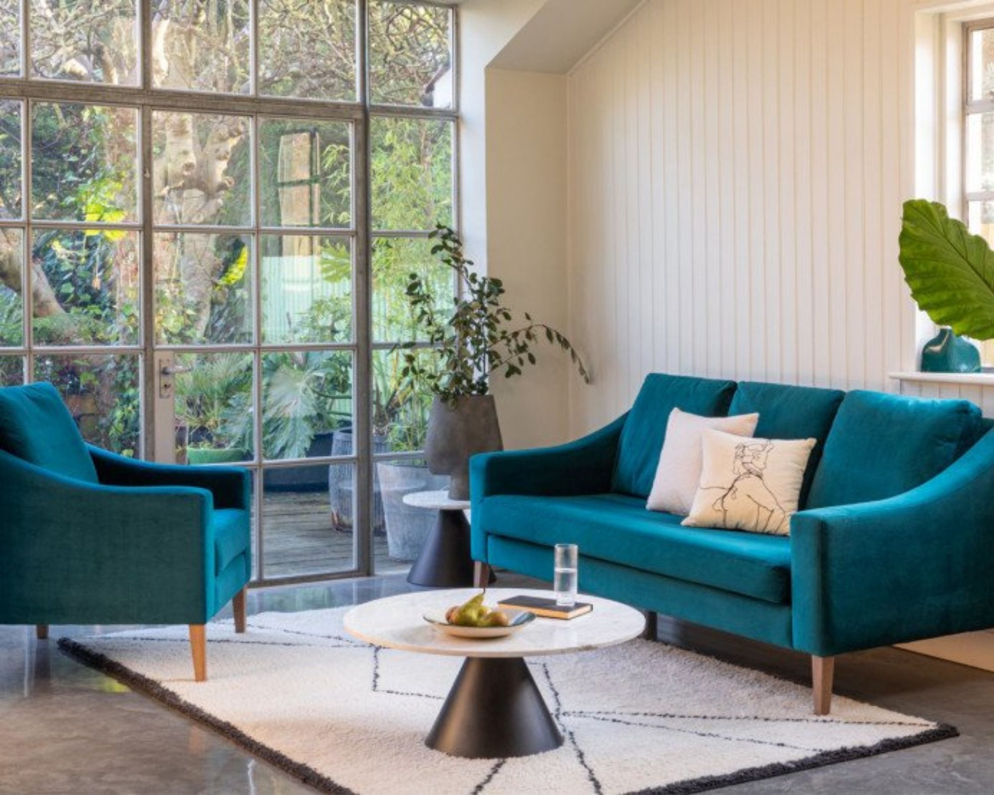 Heal's Berber rug in living room with blue vibrant sofas and marble coffee table