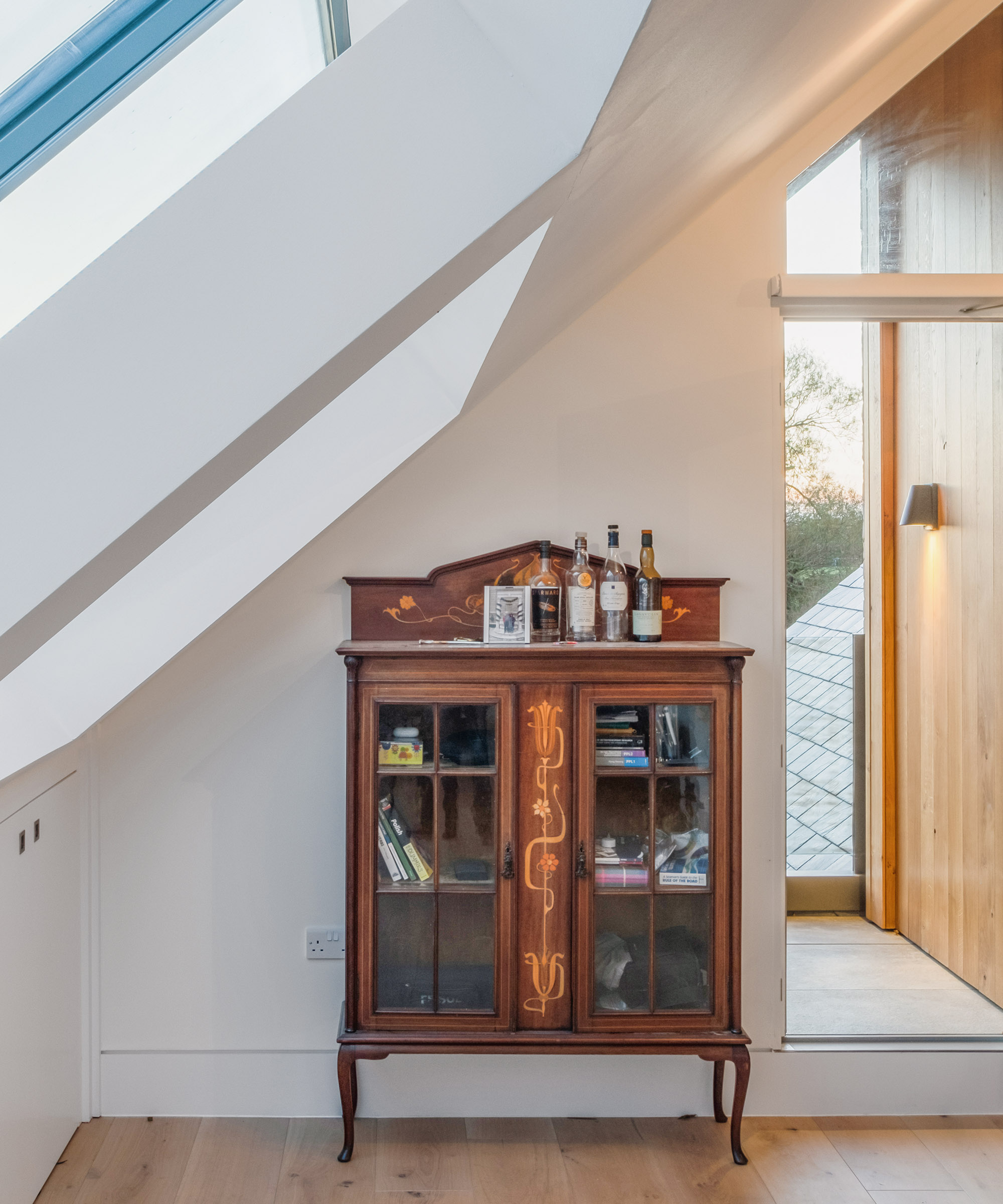 A wooden display chest on the landing of a roof room