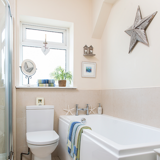 bathroom with bathtub and commode with towel