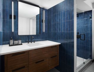 bathroom with blue tiles with wooden cabinets in the Poliform Penthouse design in Gansevoort Meatpacking hotel in Manhattan New York