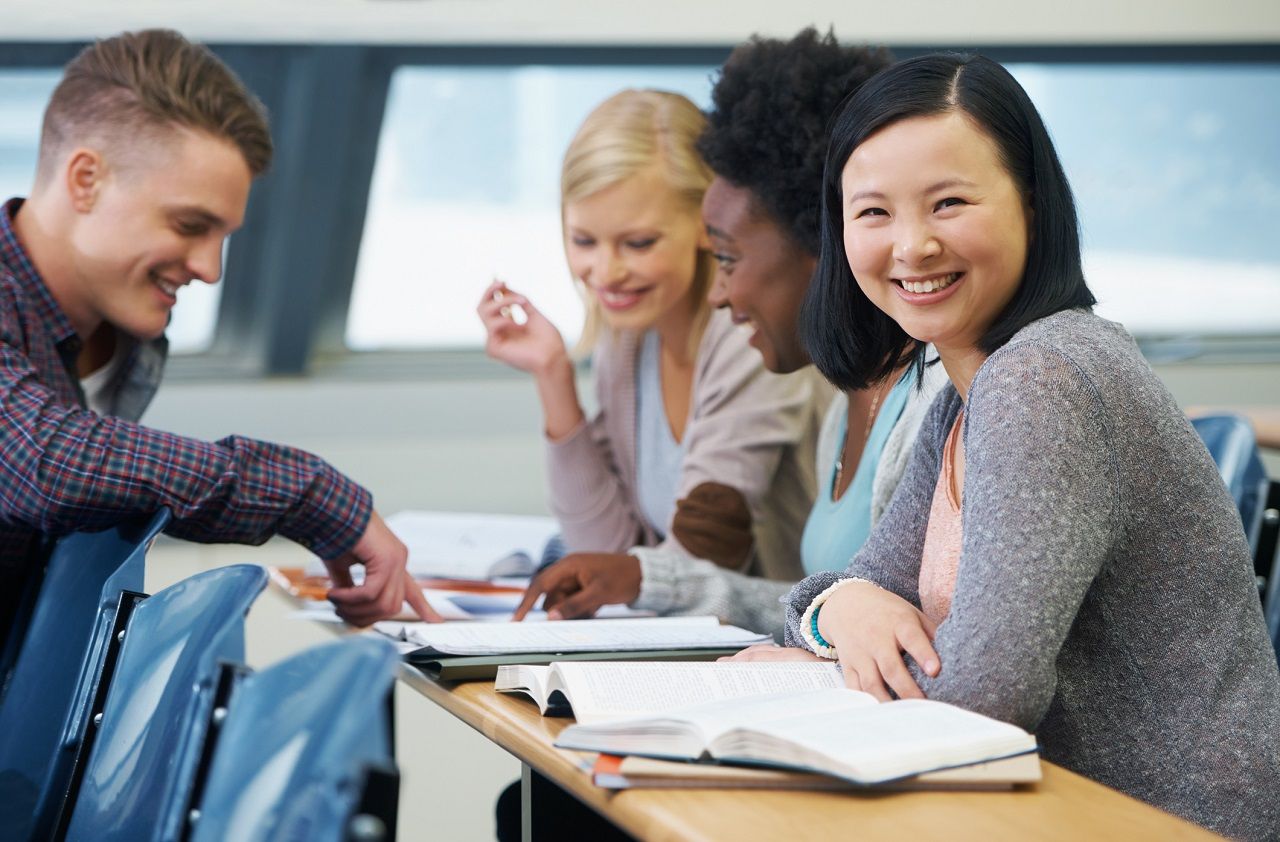 Shot of a group of university students talking to each other in a lecture hall