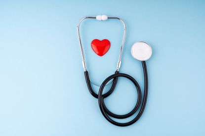 Medical Stethoscope and Heart on Blue Background Health Care Insurance Concept - stock photo