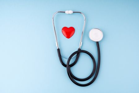 Medical Stethoscope and Heart on Blue Background Health Care Insurance Concept - stock photo