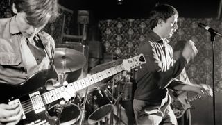 Bernard Sumner & Ian Curtis performing live onstage at Bowdon Vale Youth Club in 1979