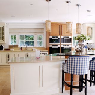 kitchen area with wooden kitchen units and white counter with chairs
