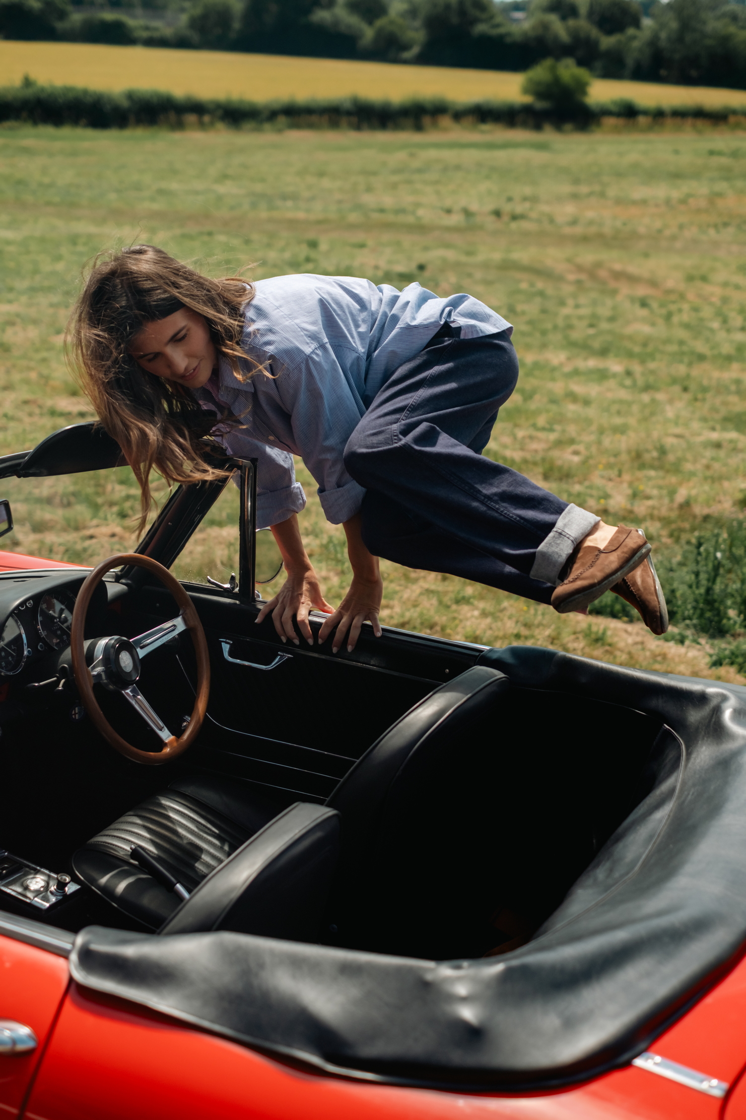 A woman hops out of a car in a pair of driving loafers from Connolly