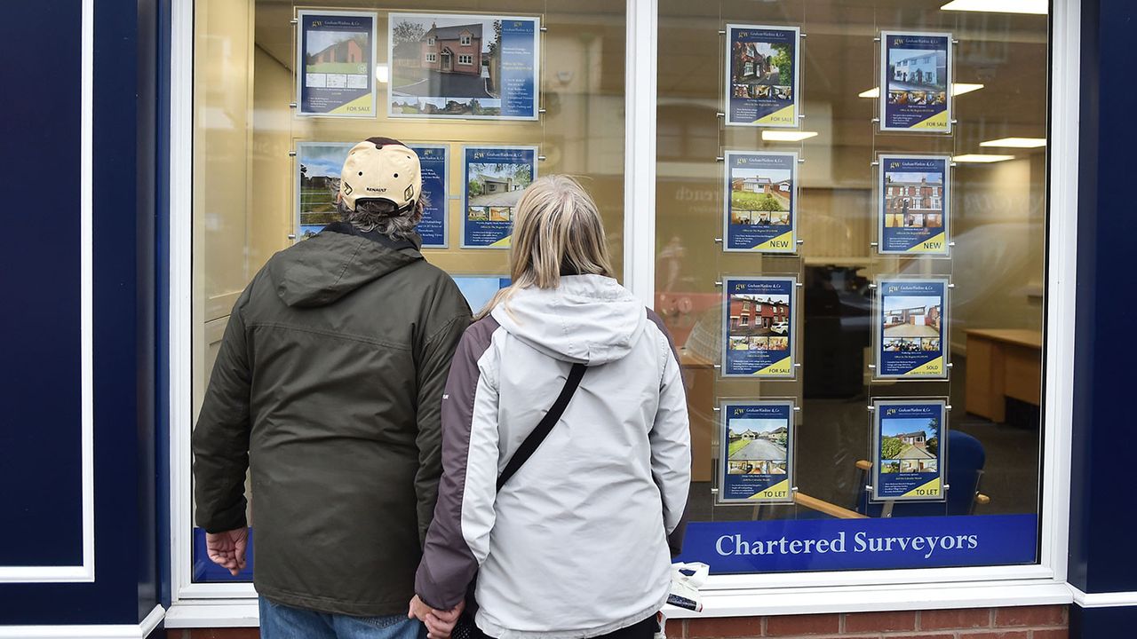 People looking in an estate agent&amp;#039;s window