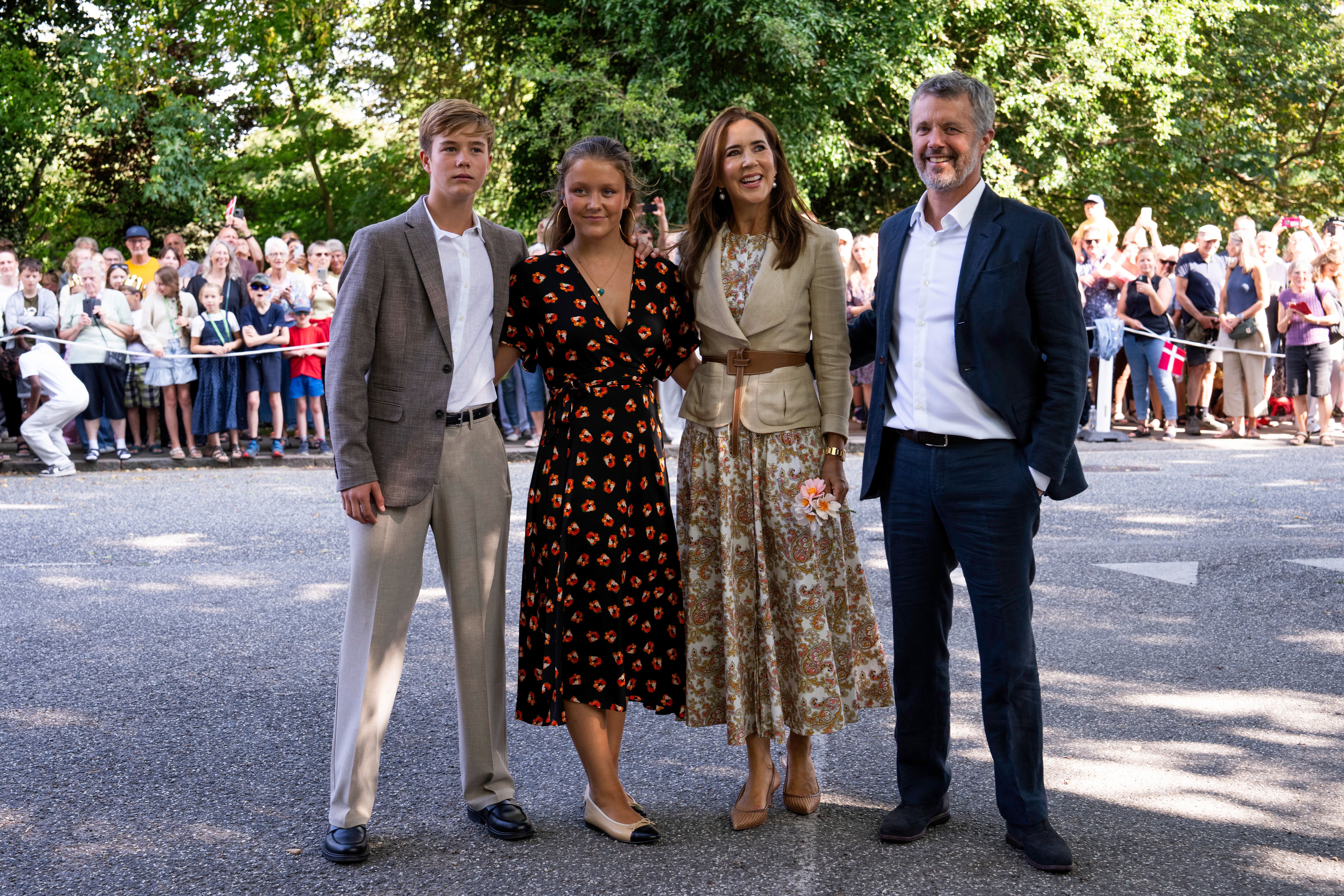 Prince Vincent, Princess Isabella, Queen Mary and King Frederik posing with their arms around each other