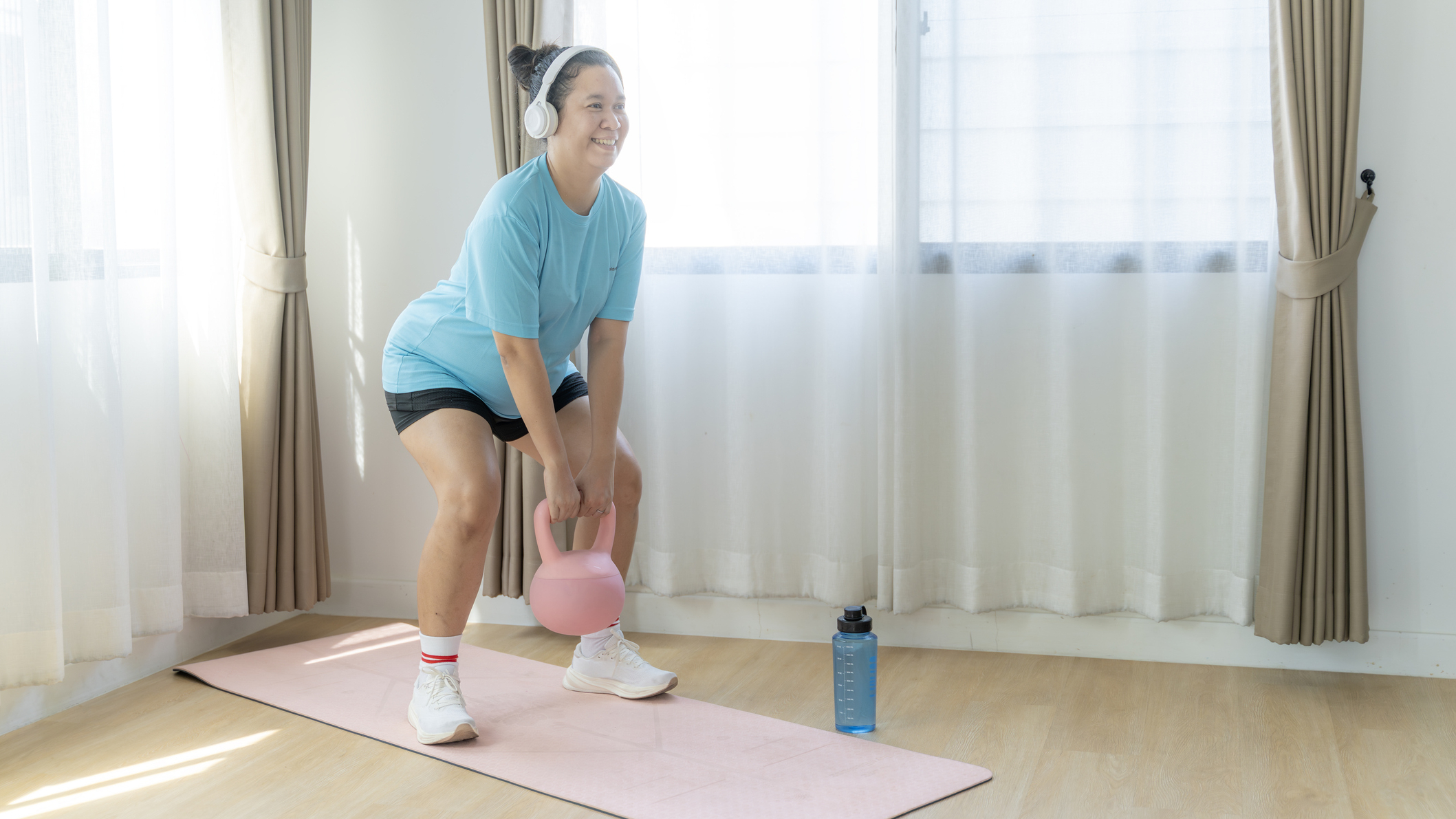 Woman exercising with kettlebell at home