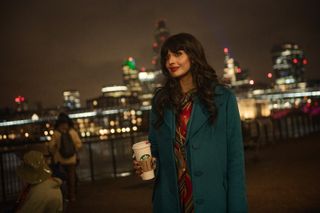 Jameela Jamil as the narrator holding a Starbucks cup with a city skyline behind her.