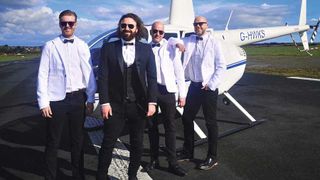 Screaming Eagles in suits next to a helicopter