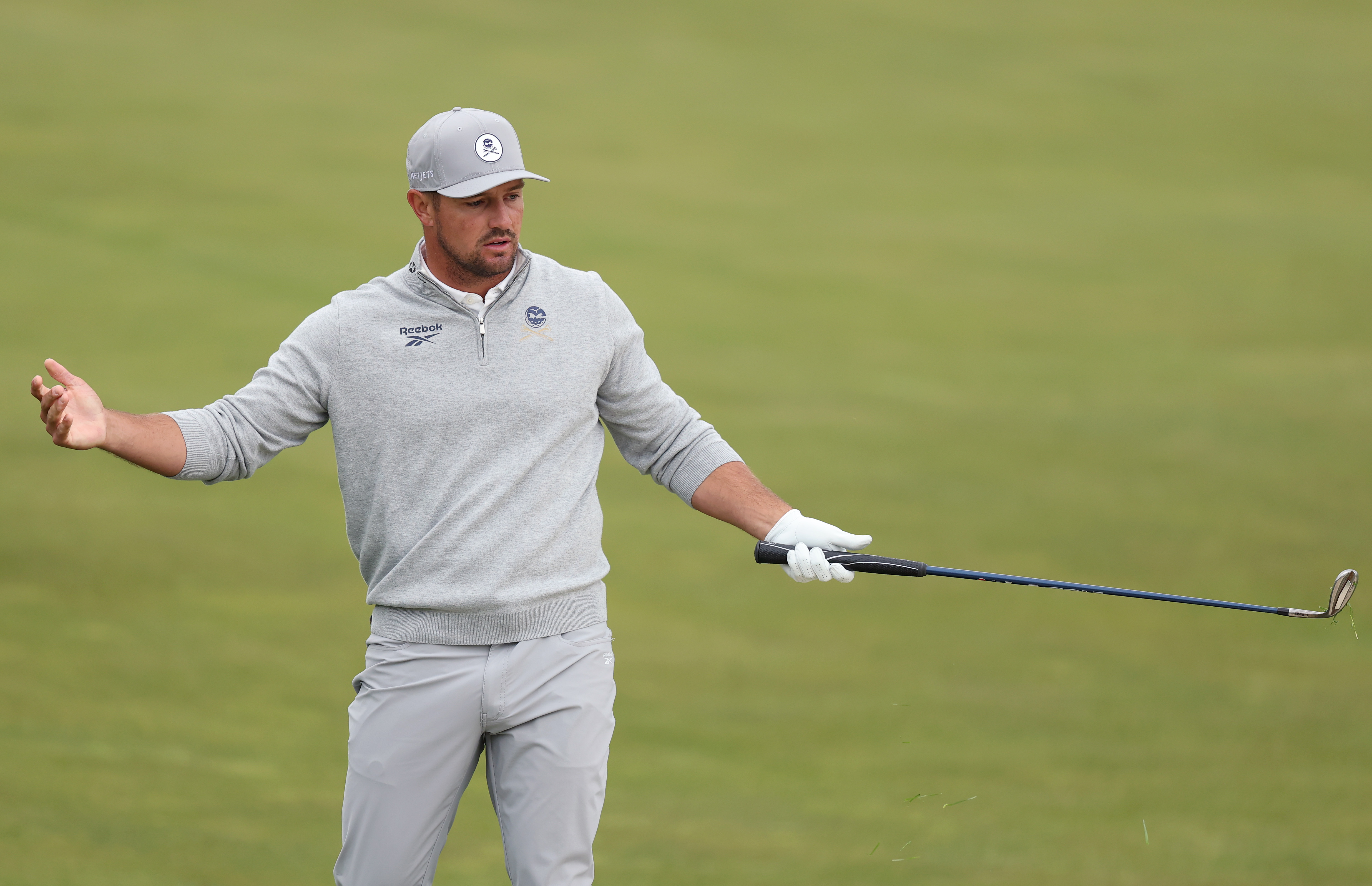 Bryson DeChambeau gestures with a wedge in his hand after a poor shot at the PGA Championship