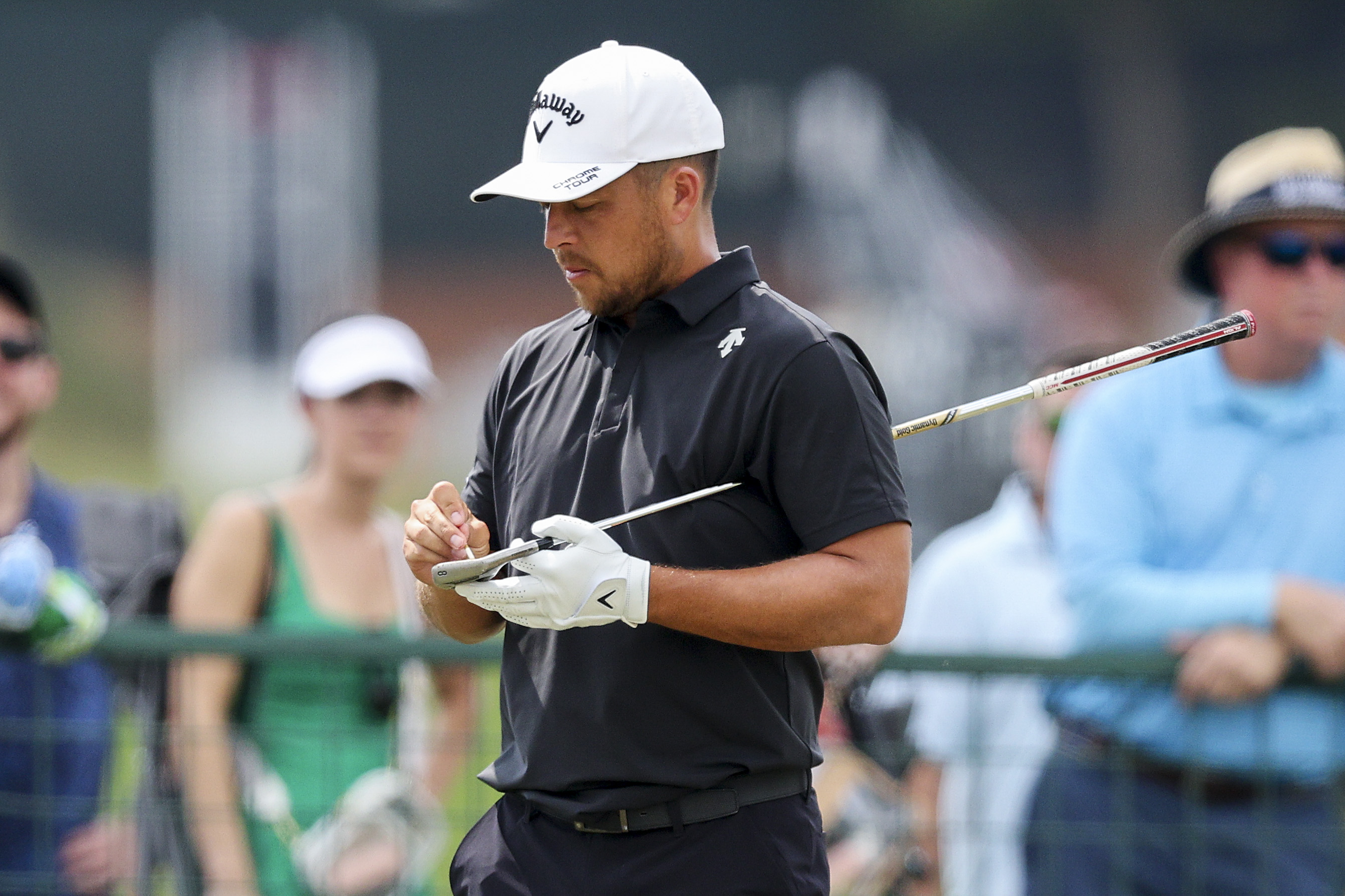 Xander Schauffele cleans the grooves of his wedge
