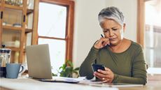 Older woman reviews her retirement savings on her smartphone.