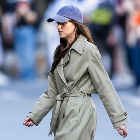 Dakota Johnson wearing a trench coat and baseball cap