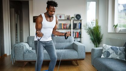 Man training with resistance bands at home
