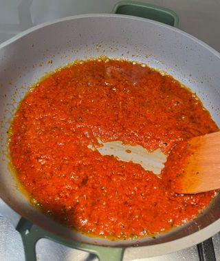 wooden spatula smoothly scraping tomato sauce on the bottom of the pan