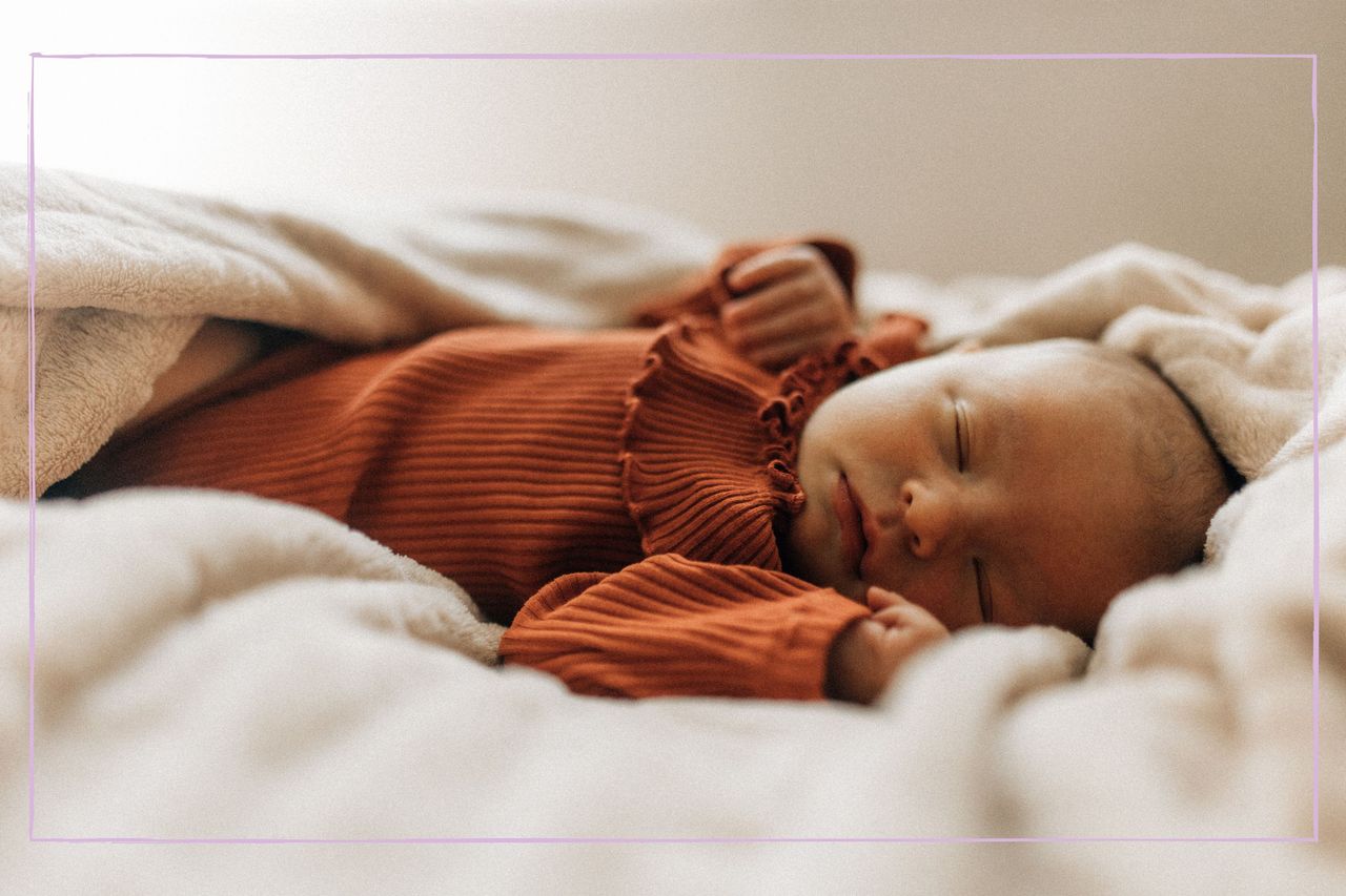 A close up of a baby sleeping on a blanket