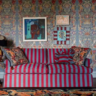 A living room with a striped red and blue sofa