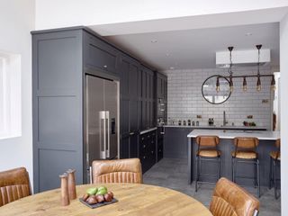 An industrial shaker style kitchen with navy cabinets and white subway tiles