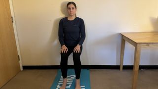 Fitness writer Daniella Gray demonstrating a wall sit as part of a wall Pilates routine