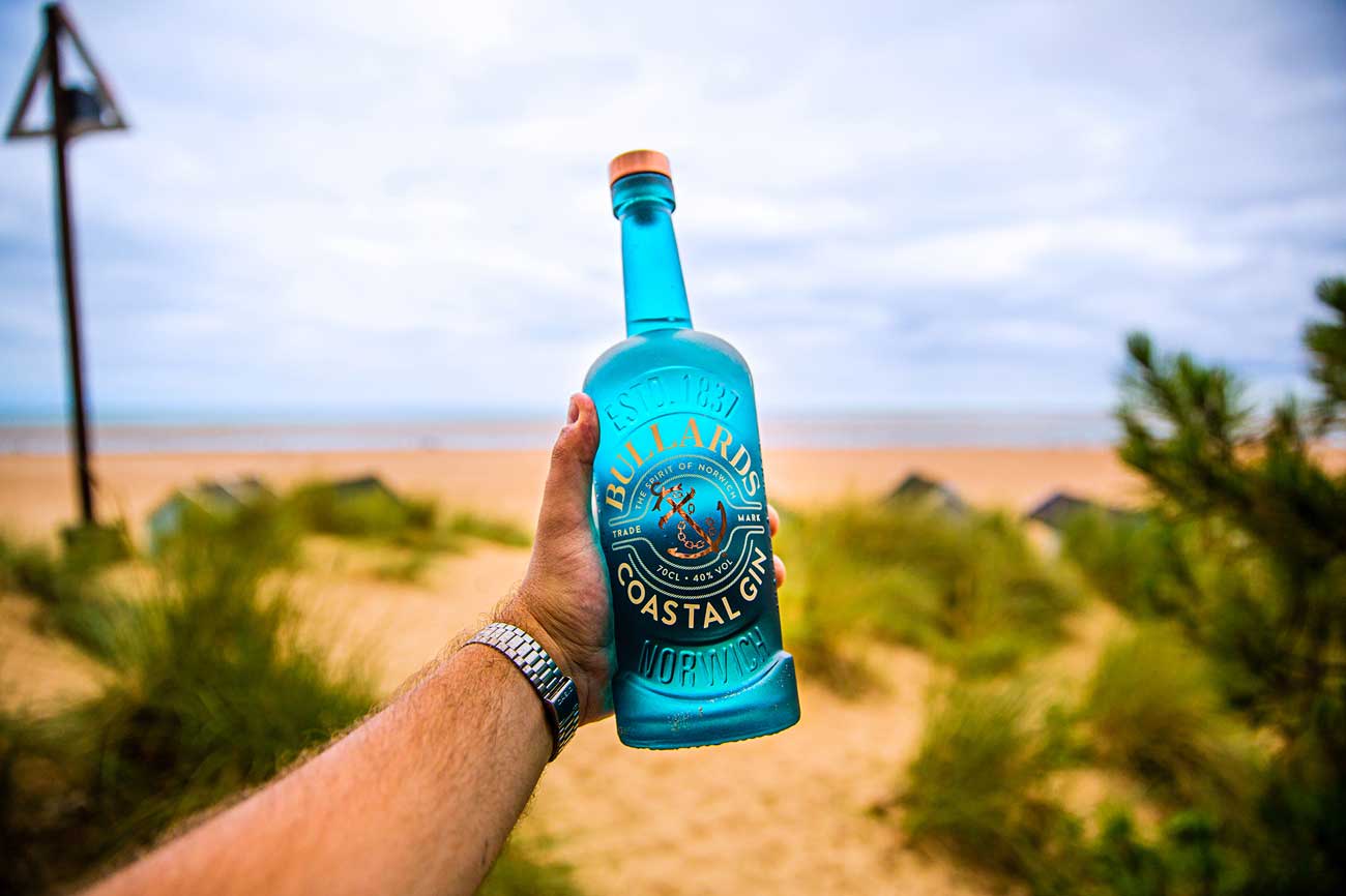 Hand holding bottle of Bullards Coastal Gin with outdoor background