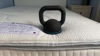 A weight rests on the surface of the Sleepeezee Cool Rest 1800 Mattress, demonstrating pressure relief and edge support