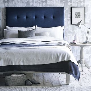 Navy blue chic upholstered bed with white linen