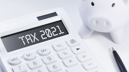 Calculator showing 2021 next to piggy bank