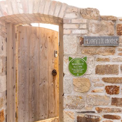 name plate on stone wall with wooden door