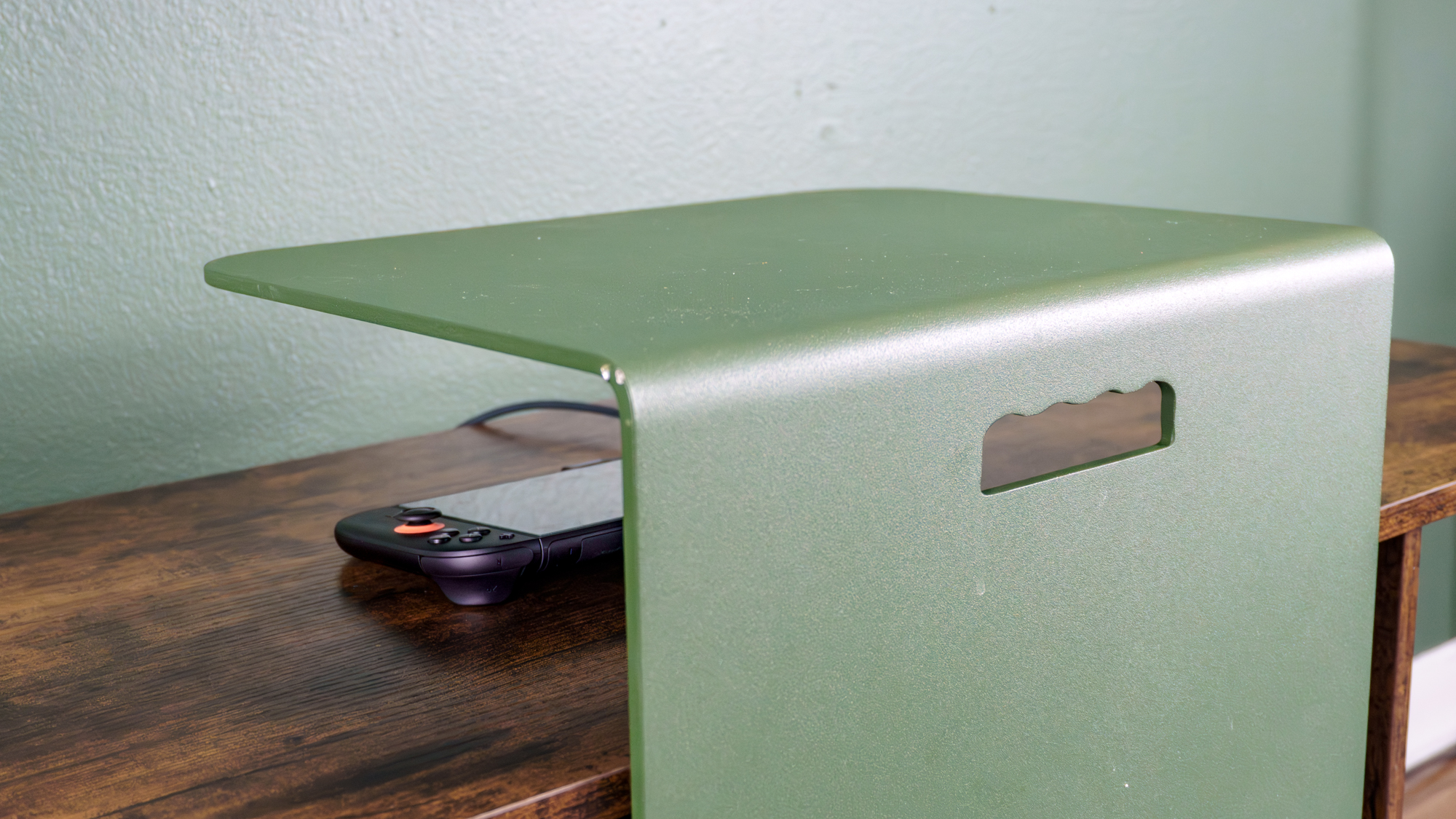 یک Nintendo Switch 2 در یک Genki Covert Dock 3 متصل به تلویزیونی که توسط Haworth Elements Table از دید پنهان شده است.