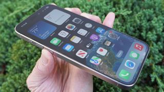 Das iPhone 15 Pro Max mit dem Display nach oben, in der Hand gehalten