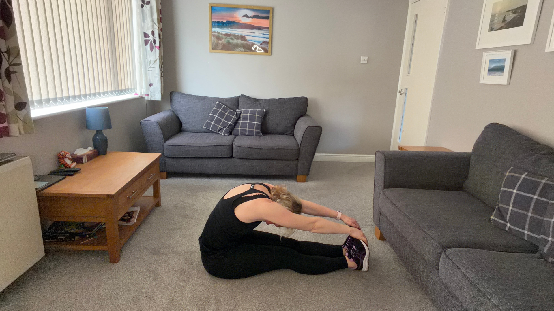 Personal trainer Becky Fuller performing stretching demonstrations in a living room