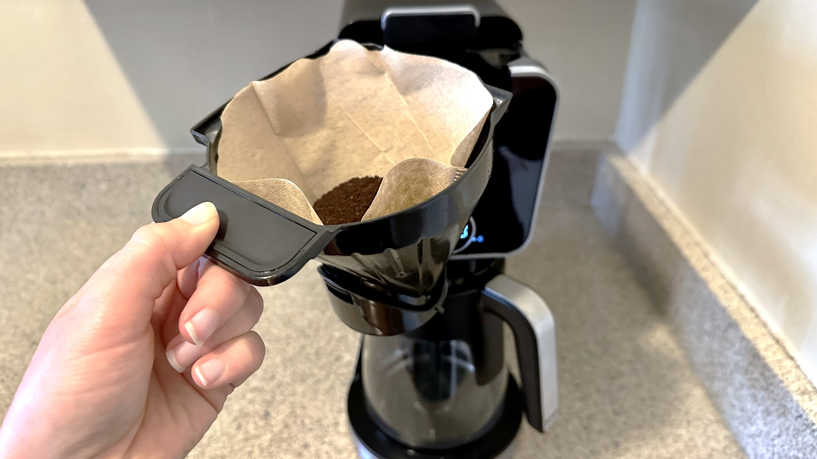 Placing ground coffee in Ninja Dualbrew Pro coffee maker