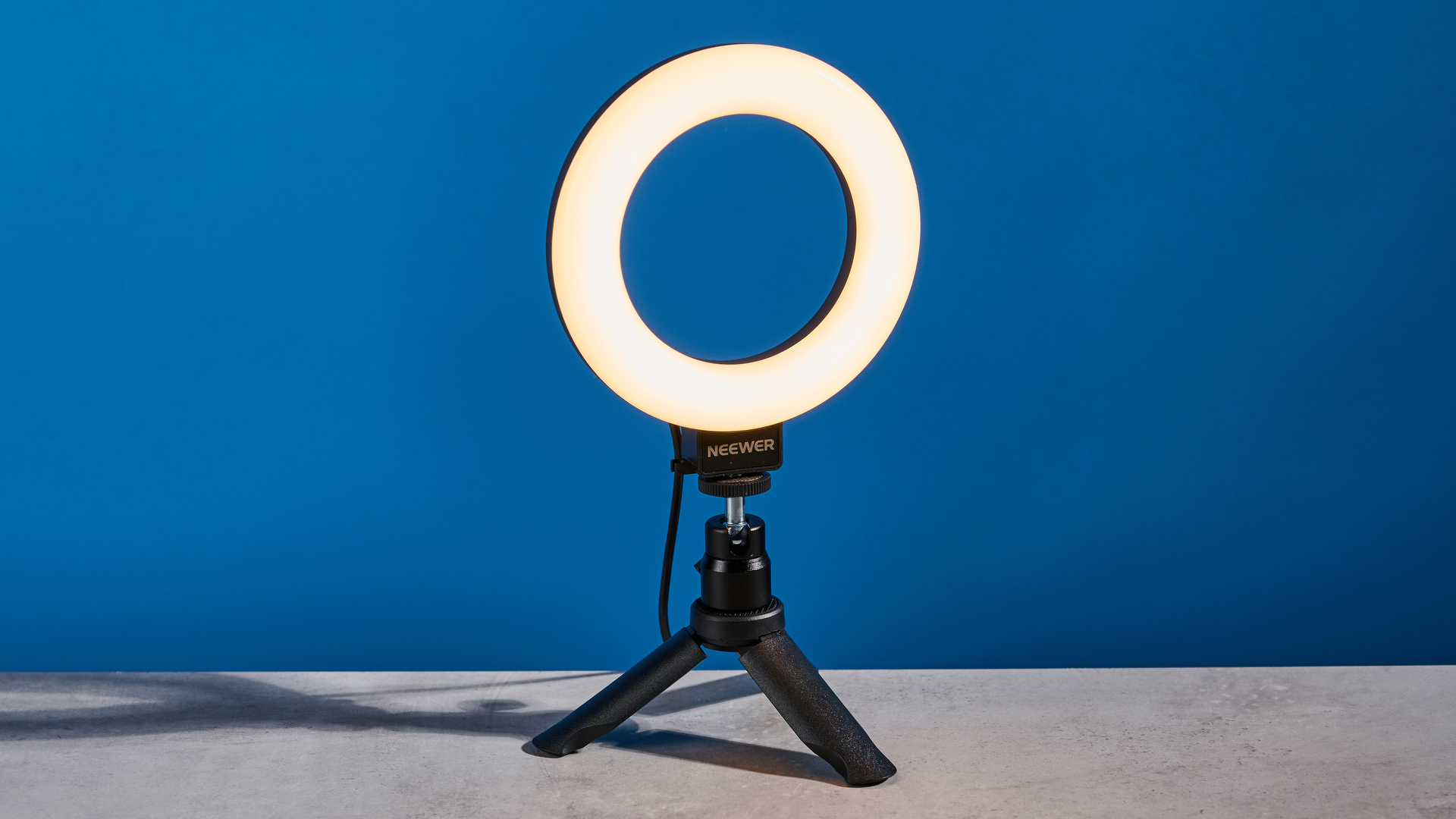The Neewer Basics BR60 5" Ring Light photographed in front of a blue background.