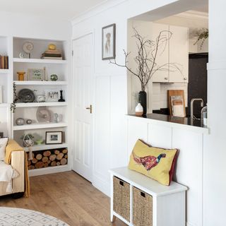 living room with white wall white shelve white door and wooden floor