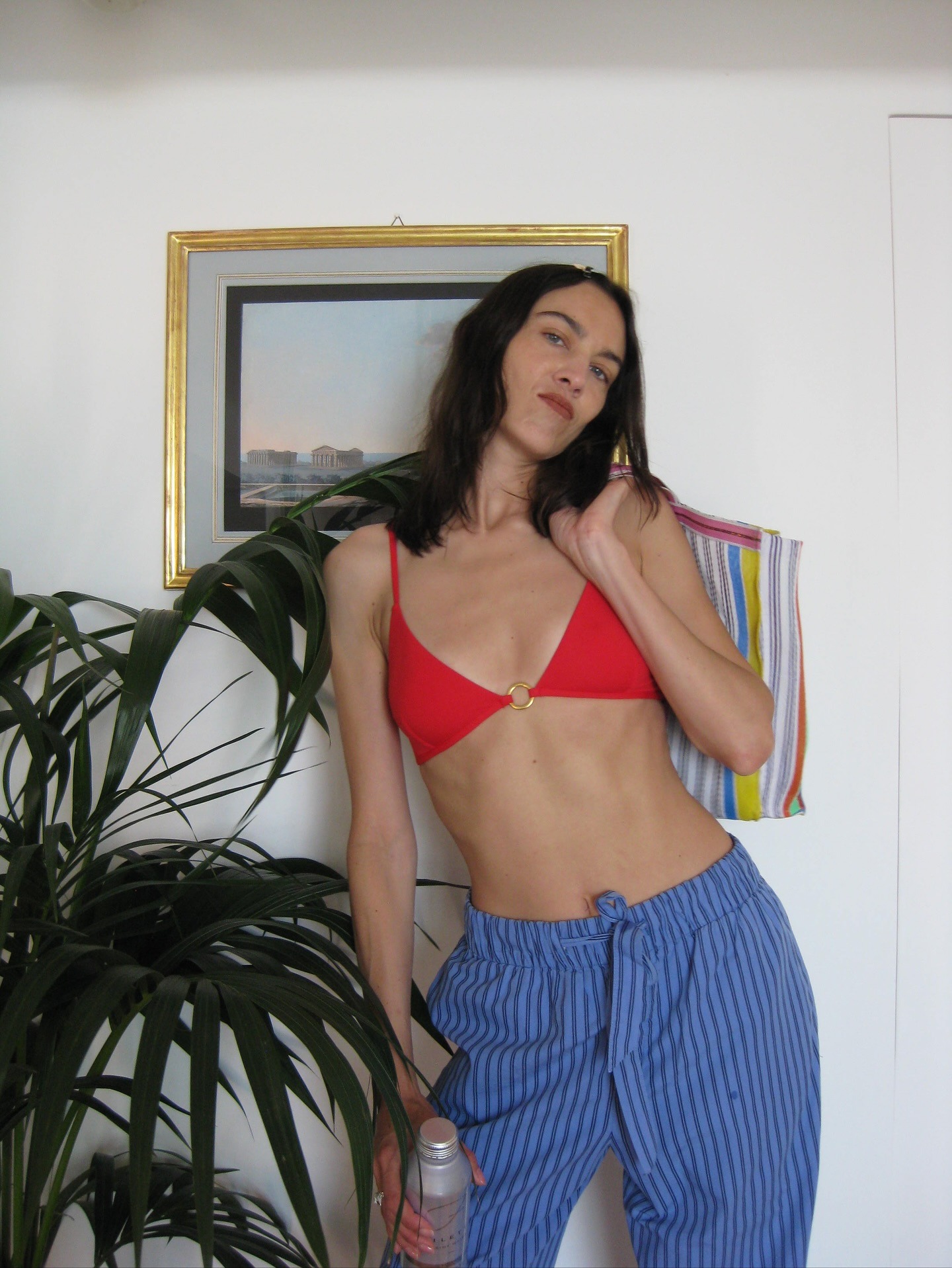 Alexa Chung wearing a red bikini with blue striped beach pants.