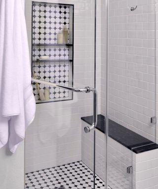 A shower enclosure with vintage monochrome tiling and matching shower floor tiles