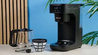 A black Instant Infusion Brew 12-Cup drip coffee maker with a removable water reservoir, glass carafe and reusable coffee filter