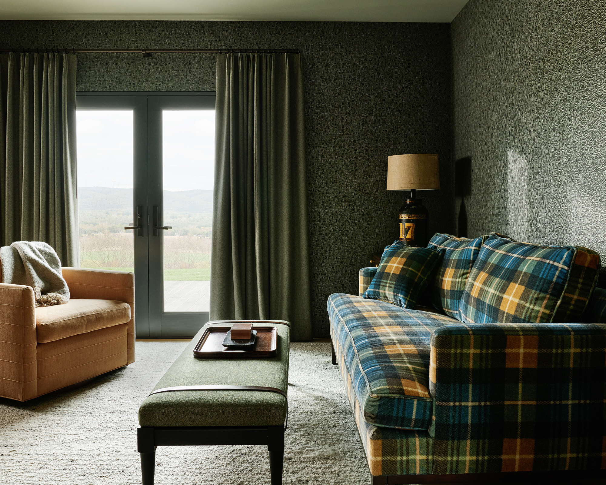 calm living room with plaid sofa and brown armchair
