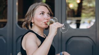 Woman drinking white wine out of wine glass