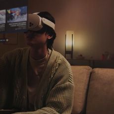 Someone watching YouTube while wearing a Meta Quest 3 sitting on a sofa in a living room