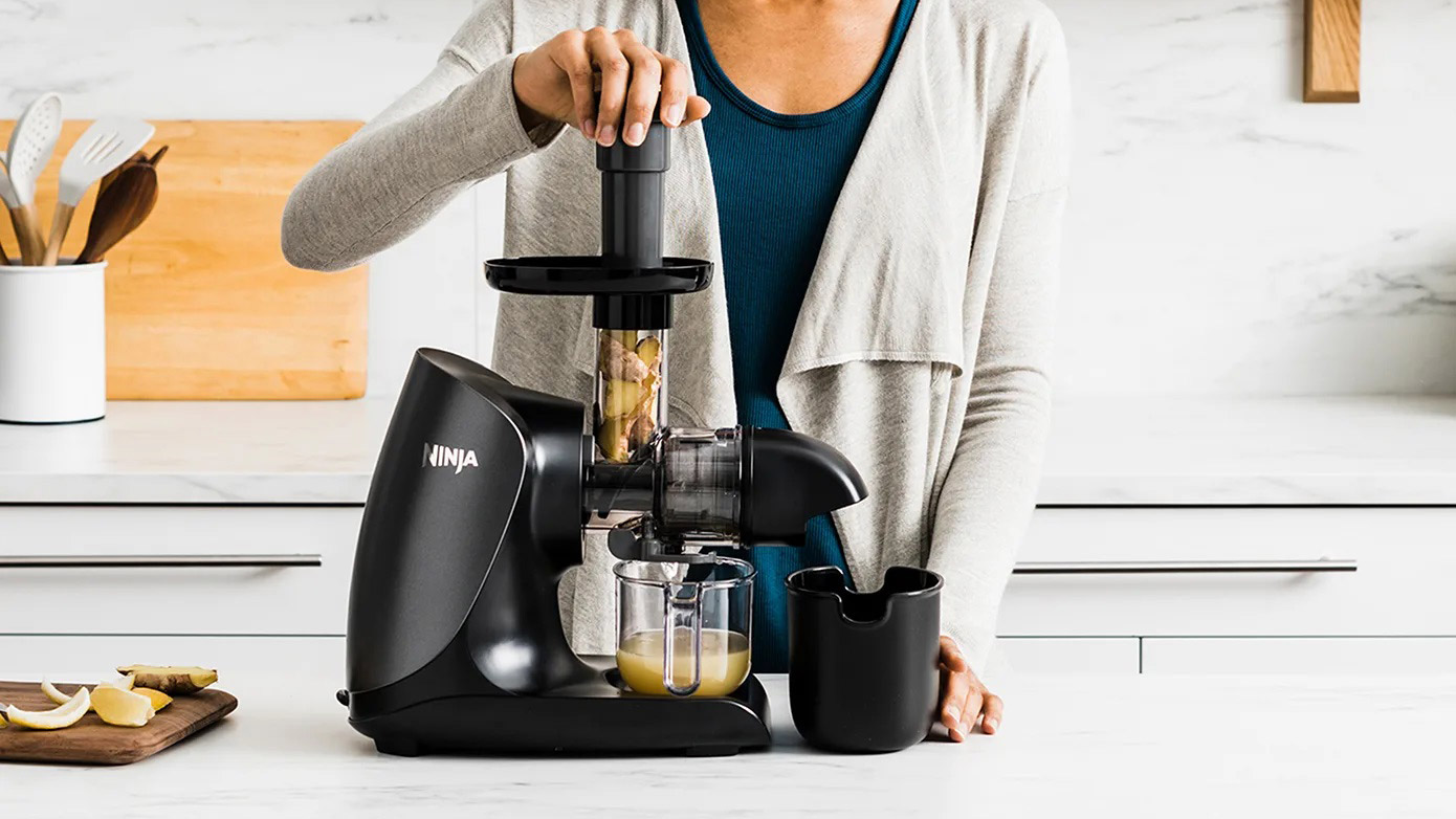 The Ninja Cold Press Juicer being used to juice apples