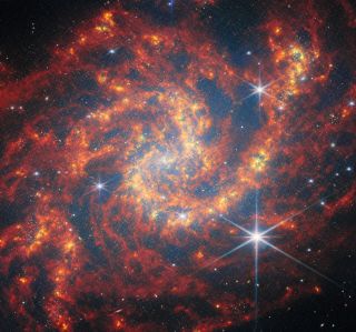 A red and orange spiral galaxy with stars.