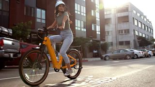 Woman riding Velotric Discover e-bike in a city